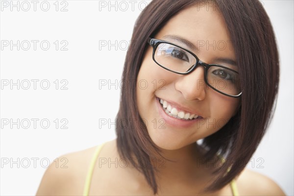 Hispanic teenage girl in eyeglasses smiling