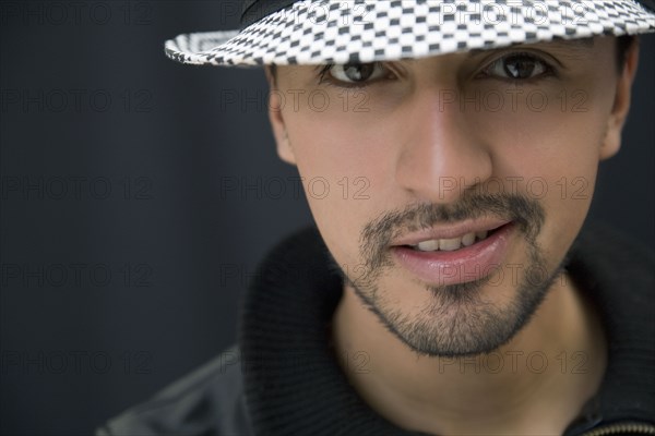 Hispanic man in hat and leather coat