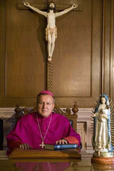 Hispanic bishop sitting with bible