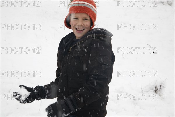 Hispanic boy throwing snowballs