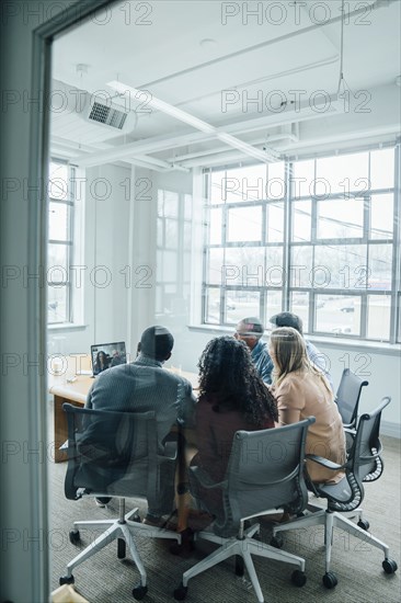 Business people on video conference behind window