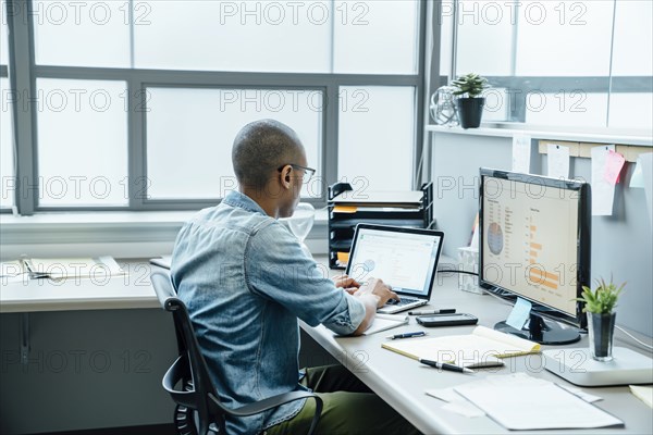 Black businessman using laptop in office