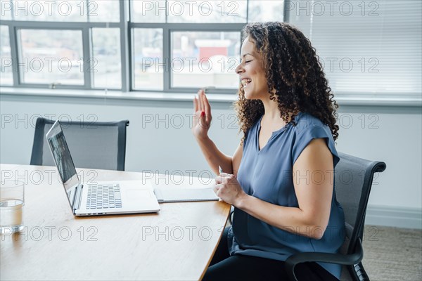 Mixed race businesswoman waving on video conference