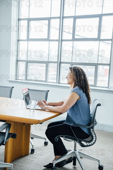 Mixed race businesswoman using laptop