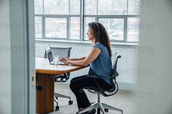 Mixed race businesswoman using laptop