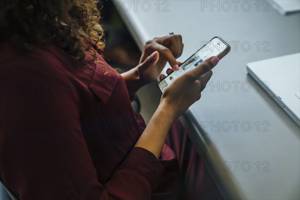 Mixed race businesswoman using cell phone