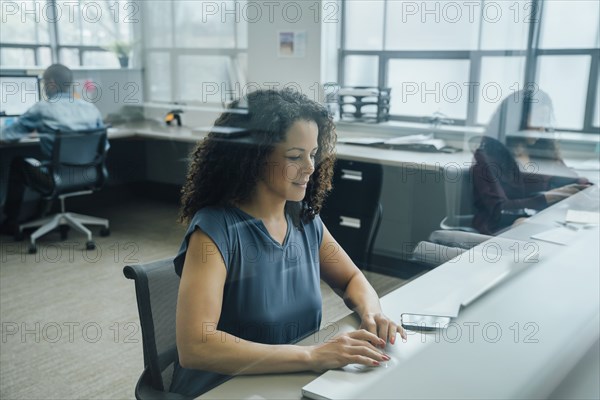 Businesswoman working in office behind window