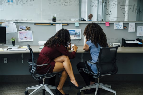 Businesswomen using cell phone in office