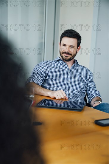 Smiling Caucasian businessman listening in meeting