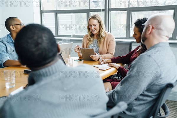 Businesswoman reading digital tablet in meeting