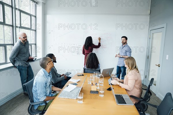 Business people using whiteboard in meeting