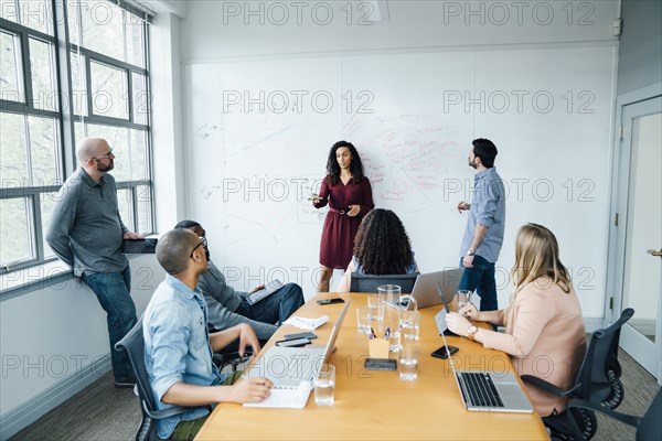 Business people using whiteboard in meeting