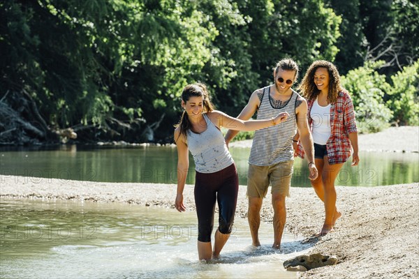 Smiling friends wading in river