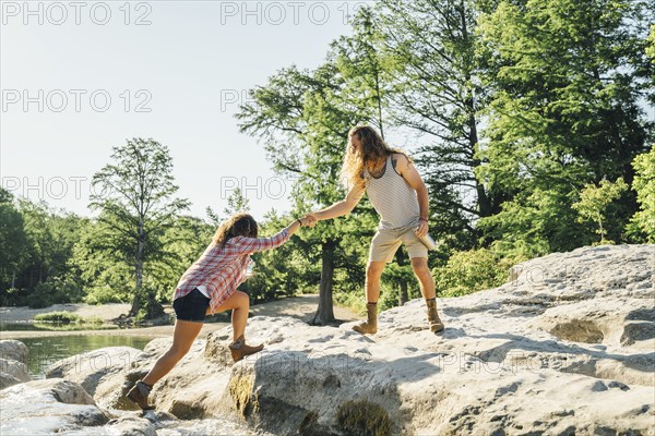 Man helping woman crossing river