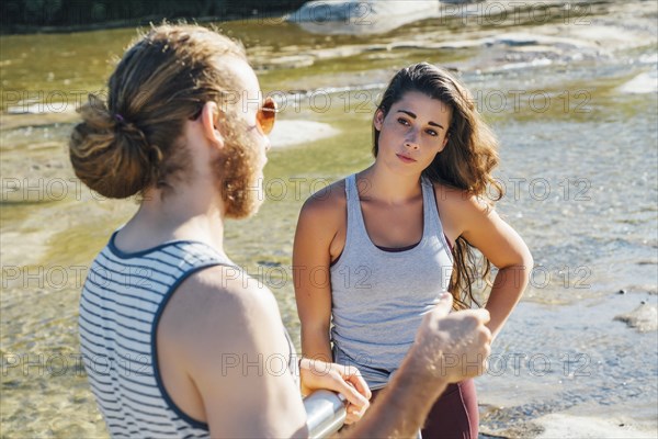 Caucasian couple talking near river