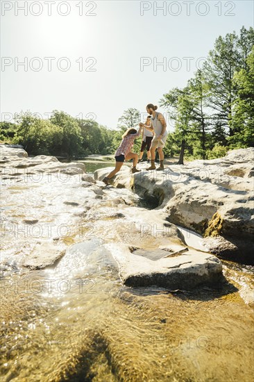 Man helping woman crossing river