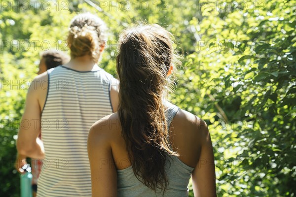 Rear view of friends walking near trees