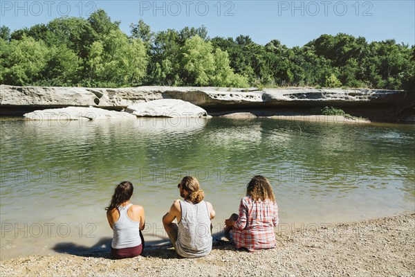 Friends sitting near river