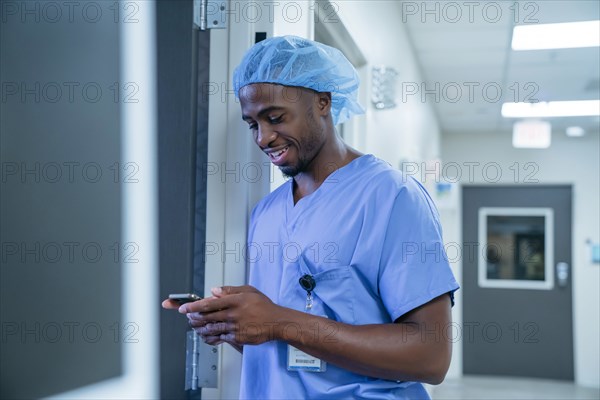 Black nurse texting on cell phone