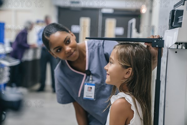 Nurse measuring height of girl