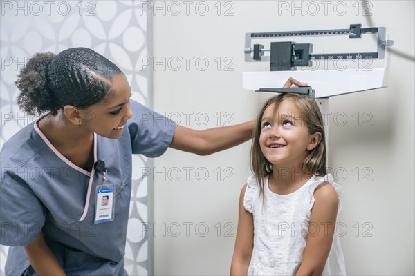 Nurse measuring height of girl