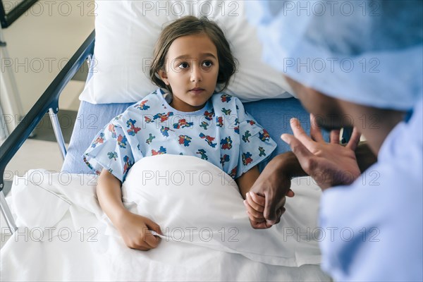 Nurse holding hands and talking to girl