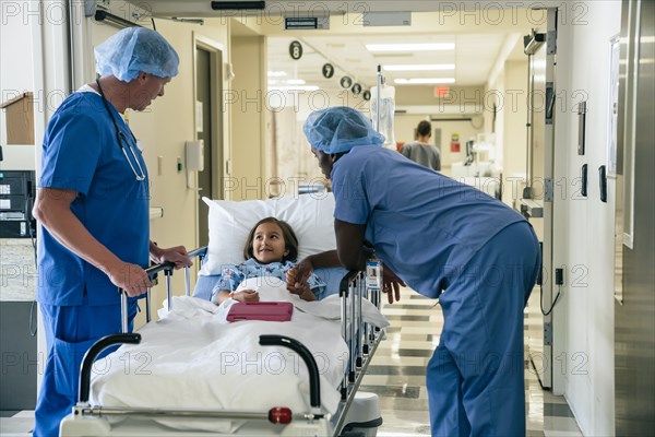 Nurses talking to girl in hospital gurney