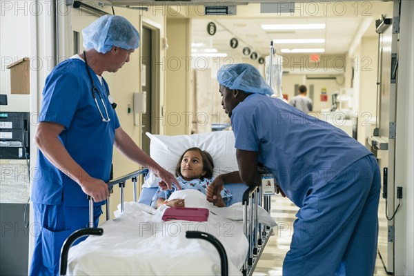 Nurses talking to girl in hospital gurney