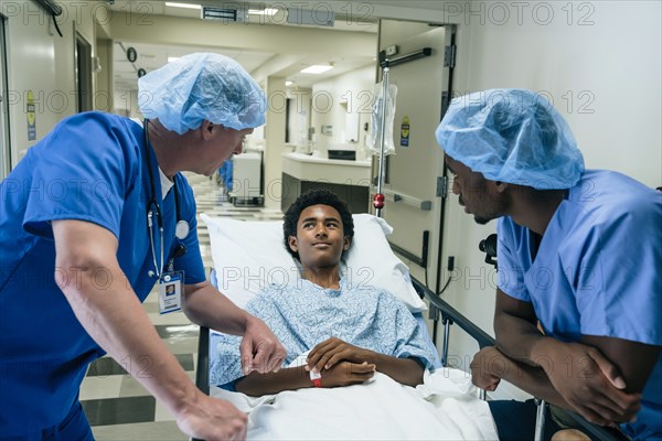 Nurses talking to boy in hospital gurney