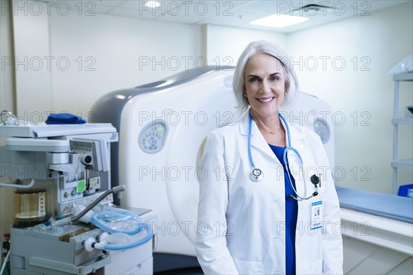 Portrait of smiling Caucasian doctor near scanner