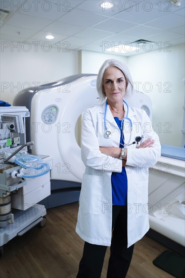 Portrait of confident Caucasian doctor near scanner