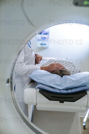 Caucasian doctor comforting patient near scanner