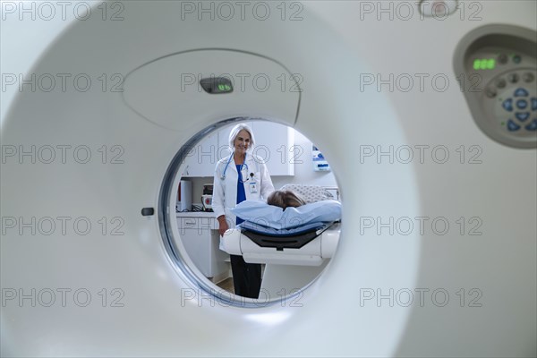 Caucasian doctor comforting patient near scanner