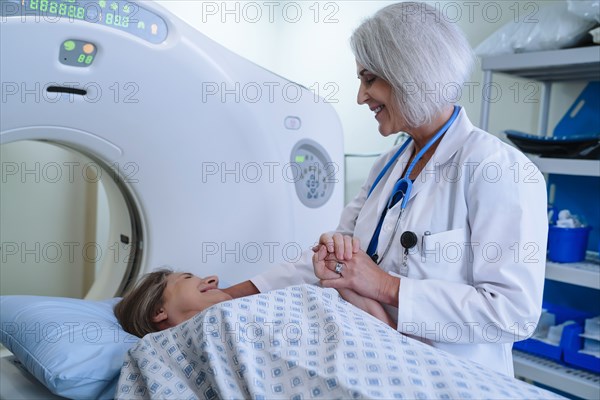 Caucasian doctor comforting patient near scanner