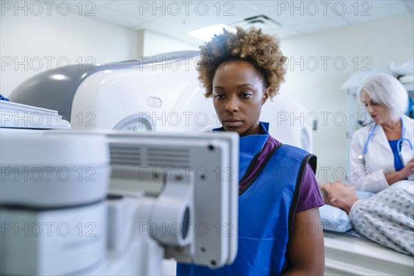 Technician preparing scanner for doctor comforting patient