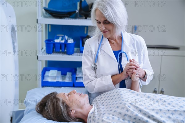 Caucasian doctor comforting patient near scanner