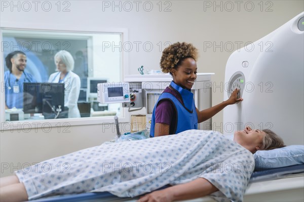 Smiling technician preparing scanner for patient