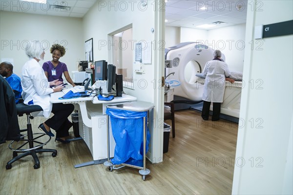 Doctor and technician talking near scanner