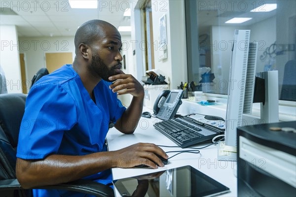 Black nurse using computer