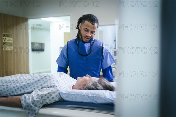 Technician talking to patient near scanner