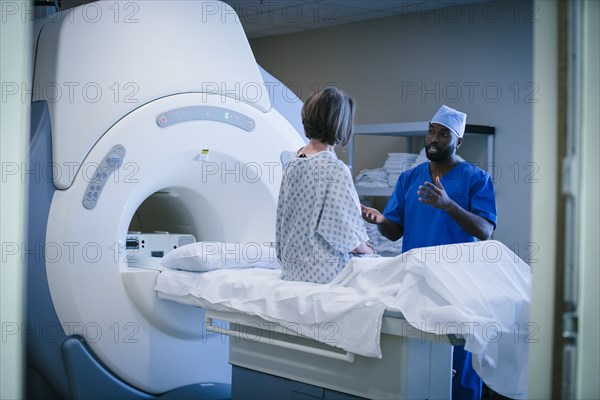 Technician talking to patient at scanner
