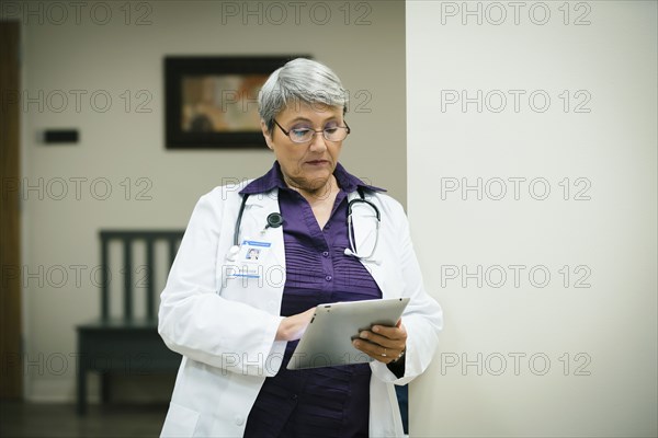 Mixed race doctor using digital tablet