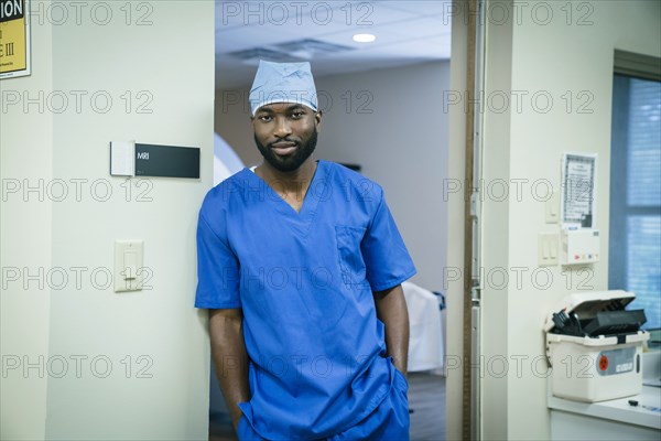 Portrait of a black nurse leaning in doorway