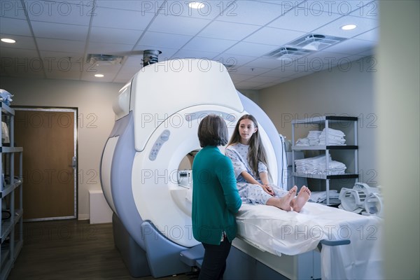 Caucasian doctor talking to patient at scanner