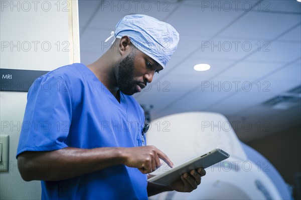 Serious black nurse using digital tablet