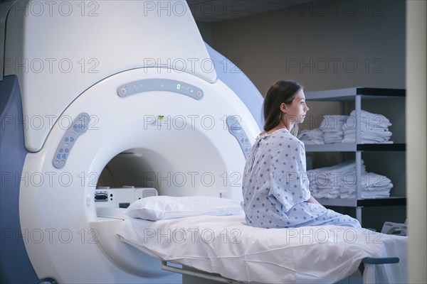 Pensive Caucasian girl sitting on scanner table