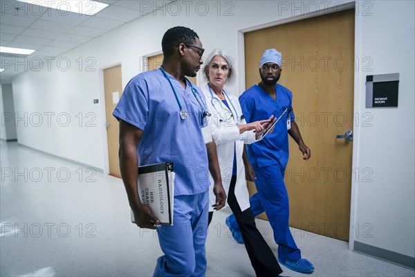 Doctor and nurses discussing digital tablet in hospital