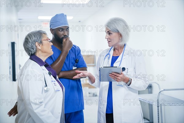 Doctors and nurse discussing digital tablet