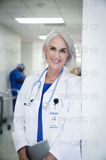 Portrait of Caucasian doctor leaning on wall in hospital