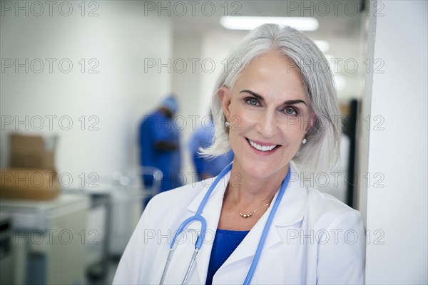 Portrait of Caucasian doctor leaning on wall in hospital